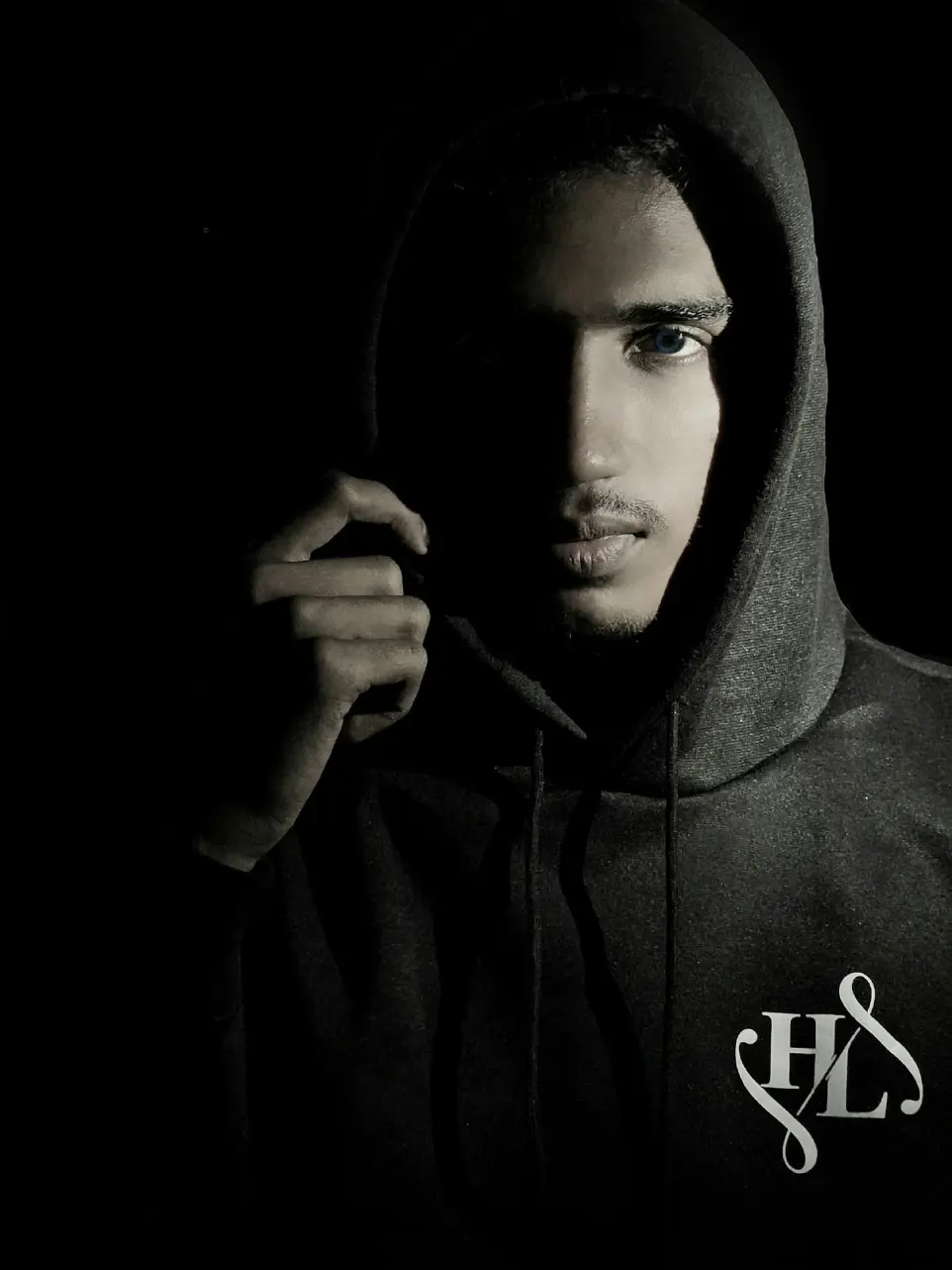 a man in a hoodie holding a cigarette